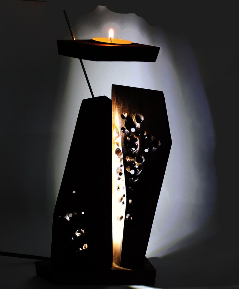 Peut inclure: Un bougeoir en bois avec un motif sculpt&eacute;. Le bougeoir a un petit sommet rond o&ugrave; une bougie peut &ecirc;tre plac&eacute;e. Le bougeoir est allum&eacute; et diffuse une lueur chaleureuse.