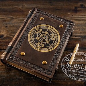 K&ouml;nnte beinhalten: Ein braunes, ledergebundenes Notizbuch mit einem goldgepr&auml;gten Design auf dem Einband, das ein kreisf&ouml;rmiges Symbol zeigt. Goldene Akzente und ein goldener Stift sind sichtbar. Das Notizbuch liegt auf einer Holzoberfl&auml;che.
