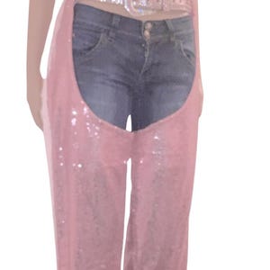 May include: Pink sequined chaps with a denim waistband and a rhinestone belt.