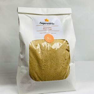 May include: A white paper bag of granulated maple sugar with a clear window. The bag has a label that reads "Maple View Sugarworks" and "Granulated Maple Sugar." The bag contains 3 lbs of sugar.