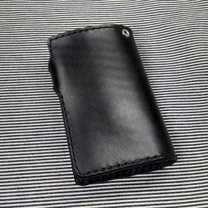 May include: A black leather wallet with a stitched edge and a silver snap closure.