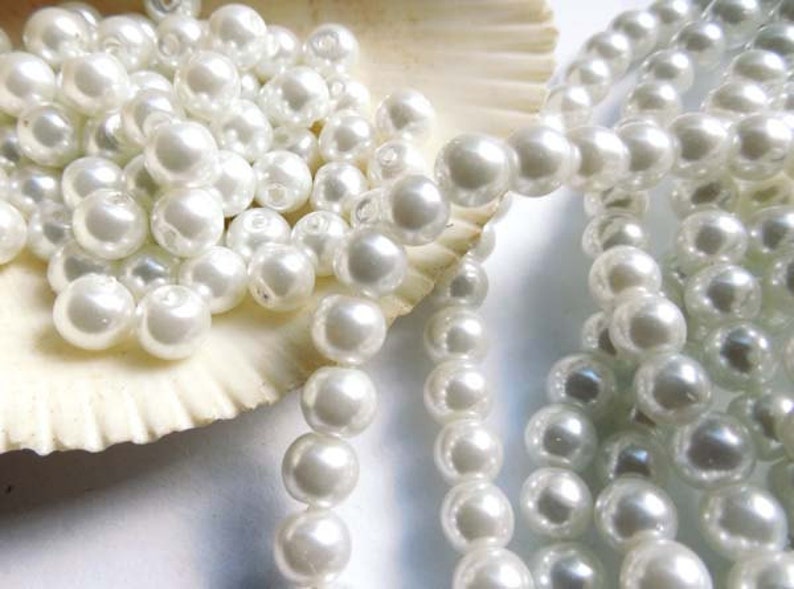 May include: A strand of white pearl beads, perfect for crafting jewelry or adding a touch of elegance to any project.