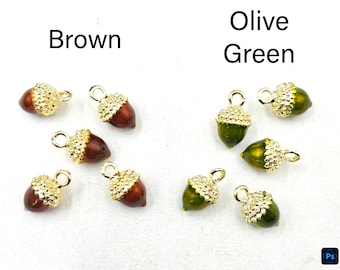 May include: A collection of acorn-shaped charms featuring smooth brown or olive green bodies and textured gold-tone metal caps. Each charm includes a small circular loop at the top for attachment. The text Brown and Olive Green labels the groups.