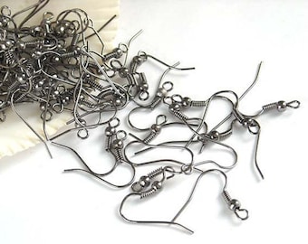 May include: A pile of silver earring hooks with a spring-loaded closure. The hooks are made of metal and have a shiny finish.