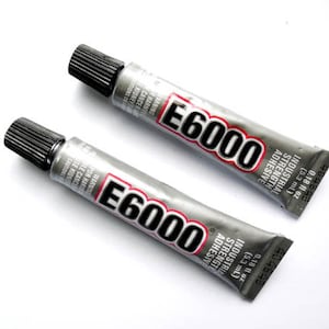 May include: Two tubes of E6000 industrial strength adhesive. The tubes are silver with black caps and red and black text. Each tube contains 0.18 fl oz (5.3 mL) of adhesive.