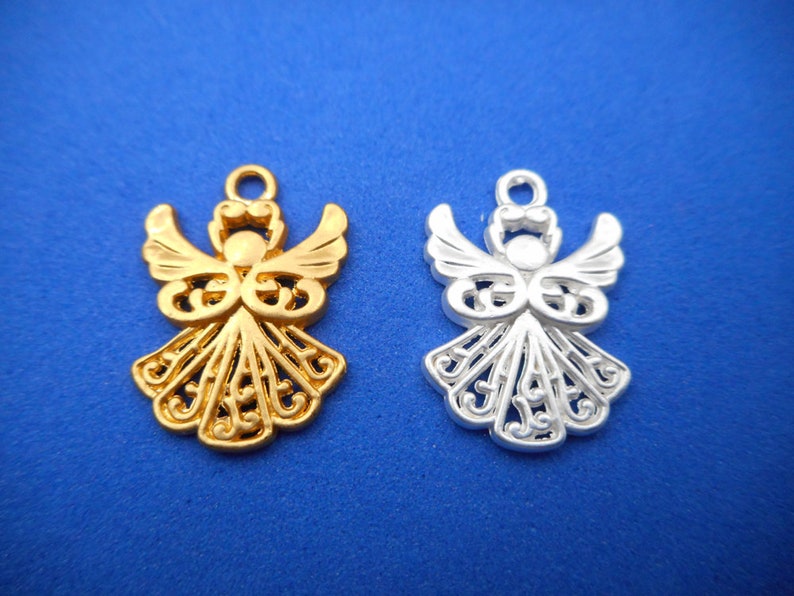 May include: Two angel charms, one gold and one silver, with intricate filigree designs. The charms are perfect for adding a touch of elegance to jewelry or crafts.