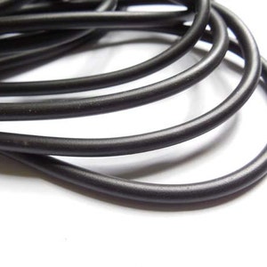 May include: A close-up of a coil of black elastic cord. The cord is smooth and flexible, and it is perfect for crafting projects.