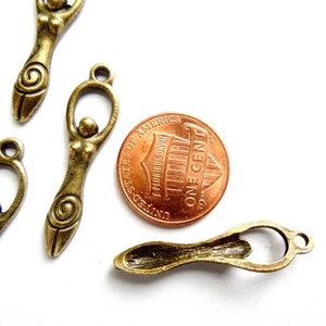 May include: Antique bronze charms featuring a stylized female figure with a spiral design. The charms are approximately the size of a US penny.