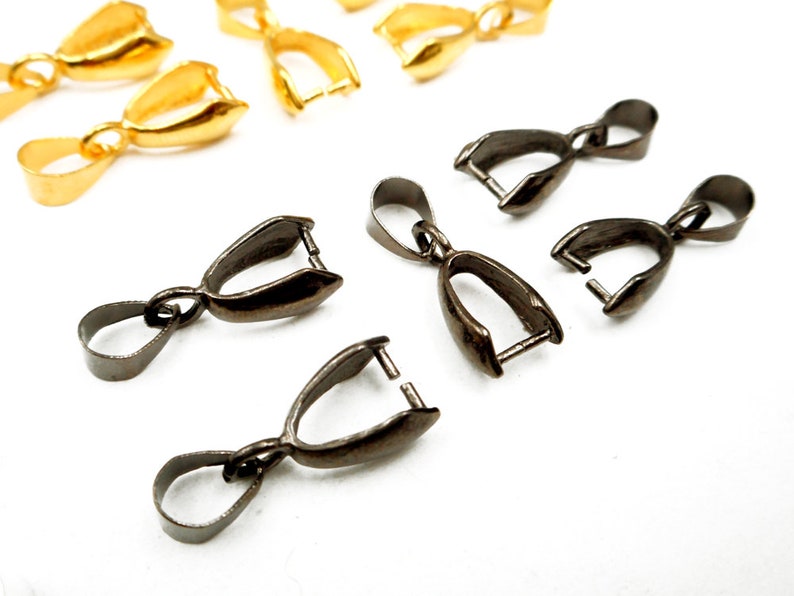 May include: A set of gold and gunmetal pendant clasps. The clasps are designed to hold a pendant or charm.