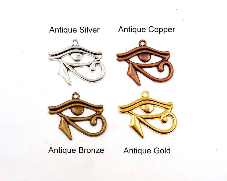 May include: Four antique silver, copper, bronze, and gold charms in the shape of the Eye of Horus, an ancient Egyptian symbol.