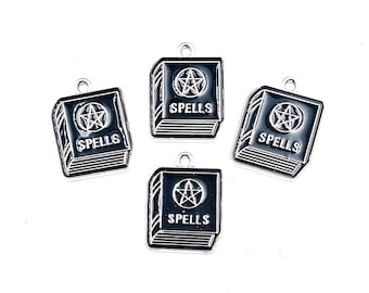 May include: Four silver-toned metal charms shaped like small books with black enamel detailing. Each charm features a pentagram symbol above the word SPELLS embossed on the cover and includes a small loop at the top for attachment purposes.