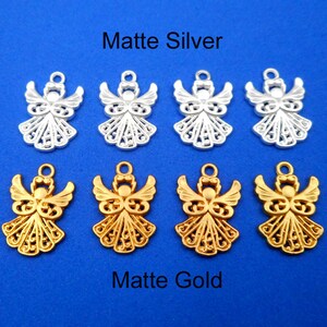 May include: Eight angel charms, four in matte silver and four in matte gold. The charms are intricately detailed and feature a delicate filigree design.