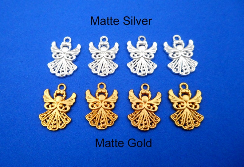 May include: Eight angel charms, four in matte silver and four in matte gold. The charms are intricately detailed and feature a delicate filigree design.