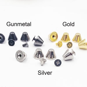 Peut inclure: Un ensemble de trois clous métalliques en forme de cône en métal gris, or et argent. Chaque ensemble comprend deux clous et deux vis.