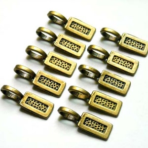 May include: Ten antique gold-toned metal pendant charms with a textured surface. Each charm has a loop at the top for attaching to a necklace or bracelet.