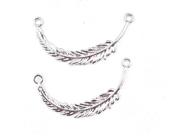 May include: Two silver-colored feather charms with a curved design. Each charm has a detailed feather pattern and a small loop at the top for attaching to jewelry or other crafts. The charms are set against a white background.