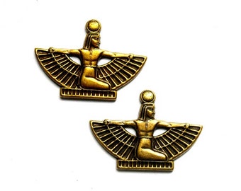 May include: Two gold-toned metal charms featuring a winged goddess figure with outstretched arms. The goddess is seated on a base with a sun disc above her head.