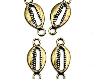 May include: Four antique brass-toned metal connectors shaped like cowrie shells. Each piece features a central elongated opening with ridged edges and a small circular loop at both the top and bottom ends for attachment in jewelry making projects.