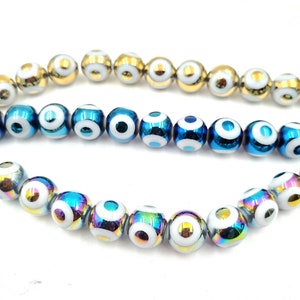 May include: A strand of iridescent blue and gold beads with white evil eye designs. The beads are round and have a smooth, shiny finish.