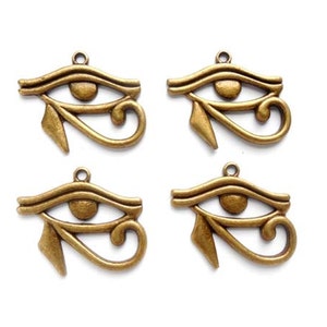 May include: Four antique gold-colored metal charms in the shape of the Eye of Horus, an ancient Egyptian symbol of protection.