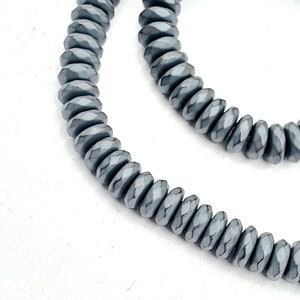 May include: A strand of gray faceted beads, strung together to form a necklace or bracelet.