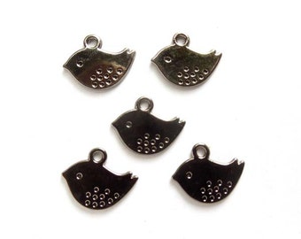 May include: Five silver metal bird charms with a dotted pattern. The charms have a loop at the top for attaching to jewellery or other crafts.