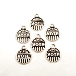 May include: Six silver charms with the word "VOTE" and five stars printed on each charm. The charms are round and have a striped design.