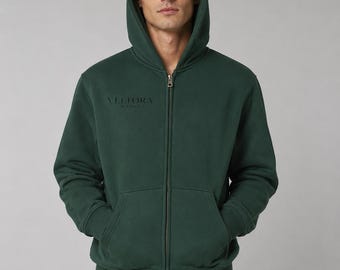 Peut inclure: Un sweat à capuche zippé vert foncé avec une capuche, des manches longues et des poignets côtelés. Le vêtement possède une fermeture éclair intégrale et une poche kangourou. Le texte Veltora Milano est imprimé en noir sur la poitrine.