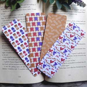 May include: Four different bookmark designs. The first bookmark features a white background with a repeated pattern of peanut butter and jelly jars. The second bookmark features a white background with a repeated pattern of peanut butter and jelly sandwiches. The third bookmark features a brown background with a repeated pattern of peanuts. The fourth bookmark features a white background with a repeated pattern of hearts and the text "peanut butter & jelly jam".