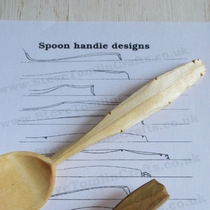 Puede incluir: Dos cucharas de madera con diferentes diseños de mango. Las cucharas están sobre una hoja de papel blanco con líneas negras dibujadas en ella. El texto "Spoon handle designs" está impreso en la parte superior de la página.