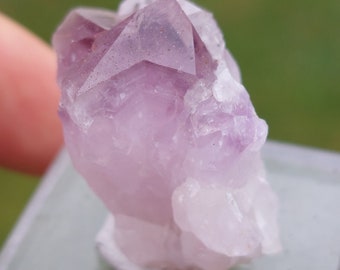 May include: A cluster of amethyst crystals with a deep purple hue. The crystals are clear and have a natural, rough texture.