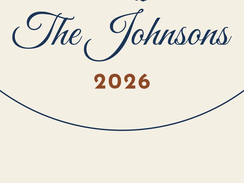 May include: A cream-colored sign featuring the dark blue text The Johnsons in a cursive script font, positioned above the brown numerical text 2026, all enclosed within a thin dark blue circular border line on a plain background.