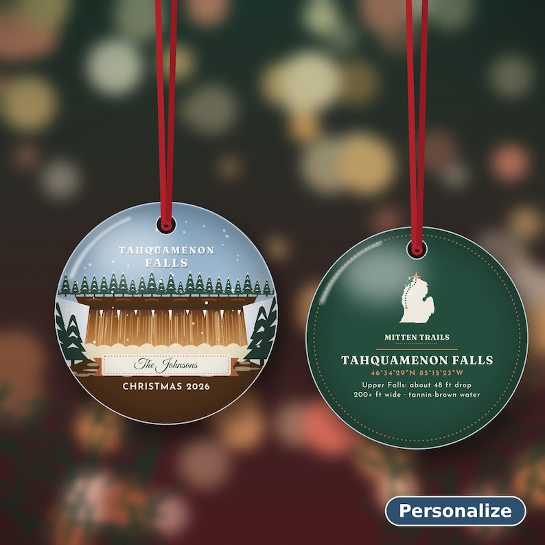 May include: Two round, flat ornaments with red hanging strings. The left ornament shows Tahquamenon Falls, The Johnsons, and Christmas 2026. The right ornament features a Michigan map, Mitten Trails, and Tahquamenon Falls text with coordinates.