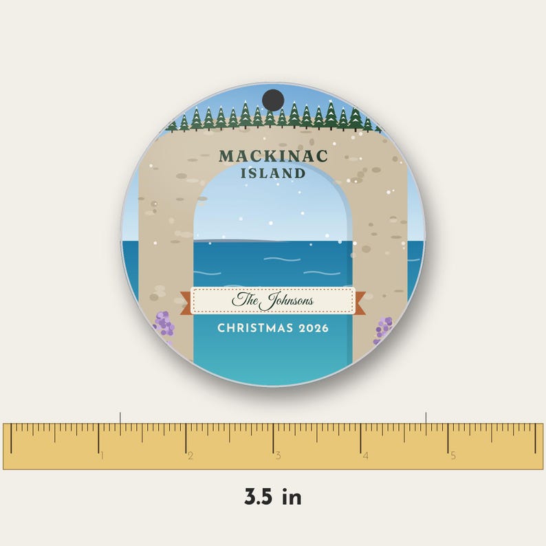 May include: A round ceramic ornament featuring a graphic of Arch Rock on Mackinac Island with a blue sky, water, and pine trees. The text reads MACKINAC ISLAND, The Johnsons, and CHRISTMAS 2026. A ruler shows a diameter of 3.5 inches.