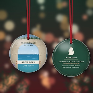 May include: Two round ceramic ornaments with red hanging ribbons. One features a graphic of Arch Rock on Mackinac Island with Lake Huron. The other is dark green with a white map of Michigan, the text Mitten Trails, and Arch Rock details.