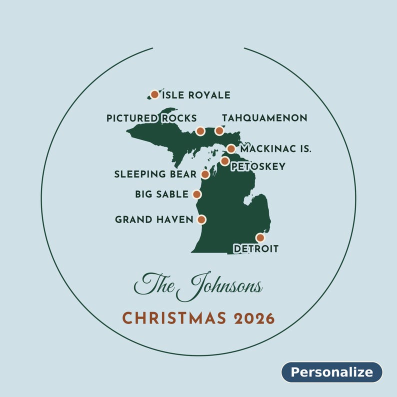 May include: A circular ornament featuring a dark green map of Michigan on a light blue background. It marks locations like Isle Royale, Pictured Rocks, and Detroit with orange dots. Text reads The Johnsons, CHRISTMAS 2026, and Personalize.