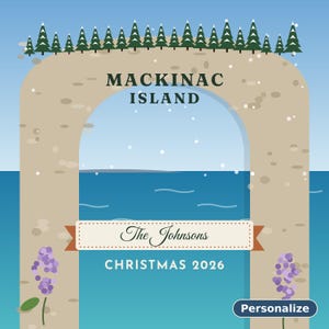 May include: A graphic illustration of the Mackinac Island Arch with a row of green pine trees on top. The center features the text MACKINAC ISLAND, The Johnsons, and CHRISTMAS 2026. Purple flowers decorate the base, set against a blue sky and water.