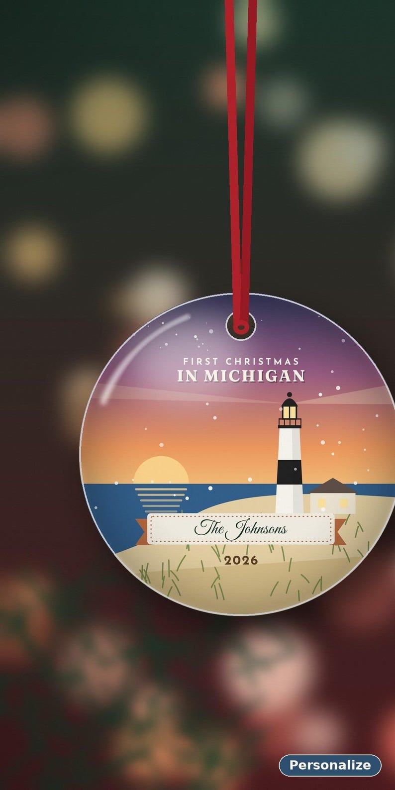Puede incluir: Un adorno navide&ntilde;o redondo y plano que cuelga de una cinta roja. El dise&ntilde;o muestra un faro en una playa al atardecer con el texto "FIRST CHRISTMAS IN MICHIGAN", "The Johnsons" y "2026" impreso en la superficie frontal.