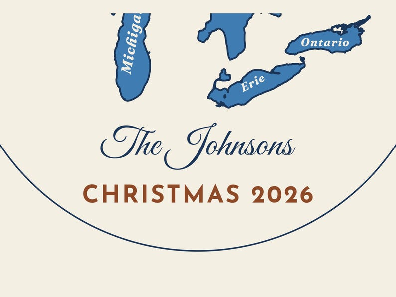 May include: A circular ornament featuring blue illustrations of Lake Michigan, Lake Erie, and Lake Ontario. The text reads The Johnsons in a dark blue script font and CHRISTMAS 2026 in a bold brown sans-serif font on a cream background.
