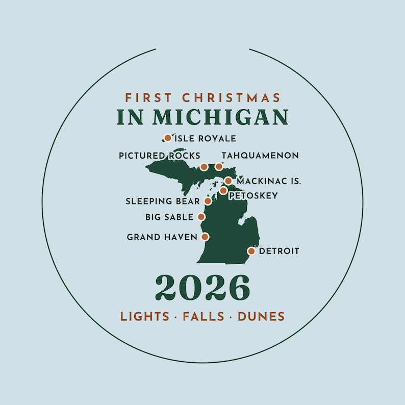 May include: A circular ornament featuring a dark green map of Michigan on a light blue background. Text reads FIRST CHRISTMAS IN MICHIGAN 2026 LIGHTS FALLS DUNES. Orange dots mark locations including Isle Royale, Pictured Rocks, and Detroit.