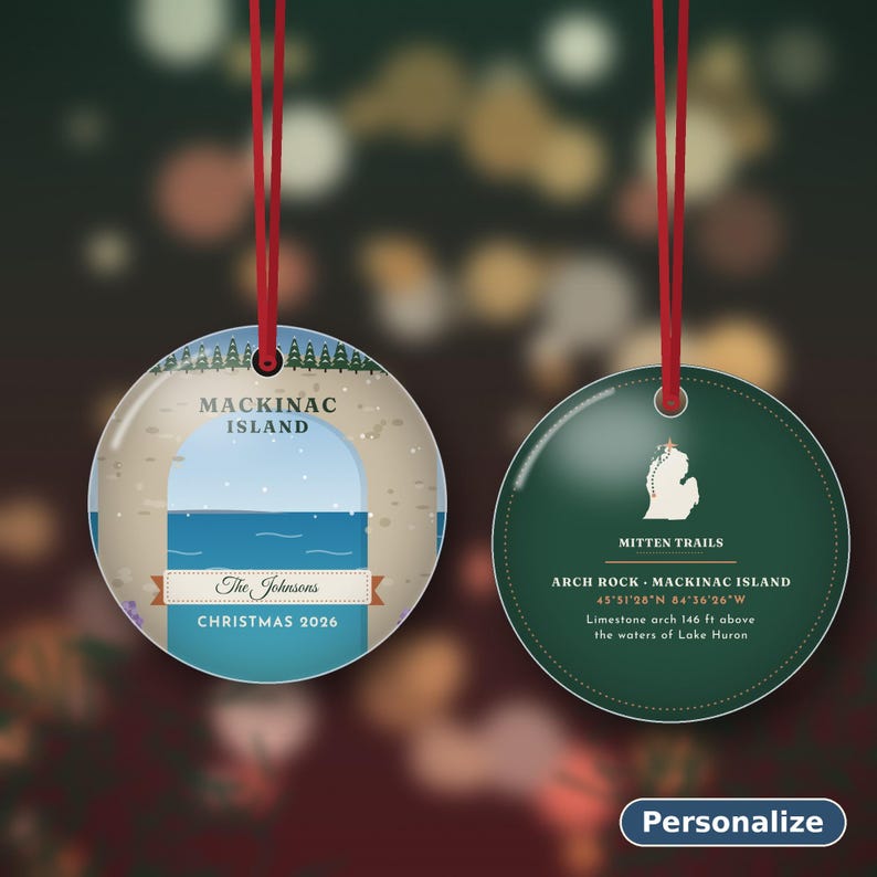 May include: Two round ceramic ornaments with red hanging ribbons. The left ornament features a Mackinac Island illustration, the text The Johnsons, and Christmas 2026. The right ornament shows a Michigan map, Mitten Trails, and Arch Rock details.