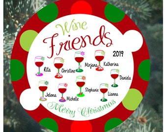 May include: Red, green and white Christmas bauble with a white circle in the centre. The circle has the text "Wine Friends 2019" and a series of wine glasses with names written below each glass. The text "Merry Christmas" is written in a circle around the bottom of the bauble.