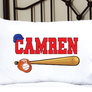 May include: White pillowcase with a red baseball themed design. The design features a baseball bat, a baseball glove, a baseball, and a blue baseball cap. The name "CAMREN" is written in red letters.