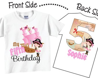 以下が含まれることがあります： 白地にピンクの海賊船と女の子の海賊が描かれたTシャツ。前面には「my fifth birthday」の文字がプリントされています。背面にはピンクの数字5と宝の地図のデザイン、そして下に「Sophie」という名前がプリントされています。