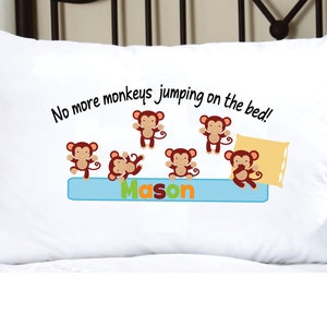 May include: White pillowcase with a blue and yellow border. The pillowcase has a design of six brown monkeys jumping on a bed with the text "No more monkeys jumping on the bed!" and the name "Mason" written in colorful letters.