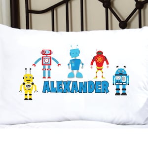 May include: White pillowcase with a blue, yellow, red, and green robot design. The name "ALEXANDER" is embroidered in blue letters.