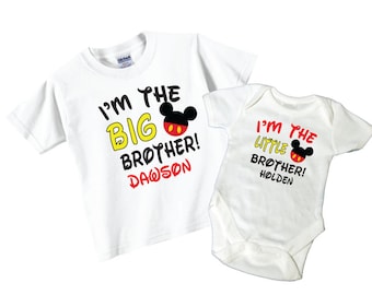 May include: Two white t-shirts with Mickey Mouse ears and the text "I'm the big brother! Dawson" and "I'm the little brother! Holden".