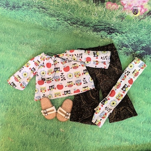 May include: A white, long-sleeved shirt with a pattern of owls and apples. Brown corduroy pants with a paisley pattern. A pair of brown sandals. The shirt and pants have a white background with a colorful owl and apple pattern. The text "Up All Night" is visible in the top right corner of the image.