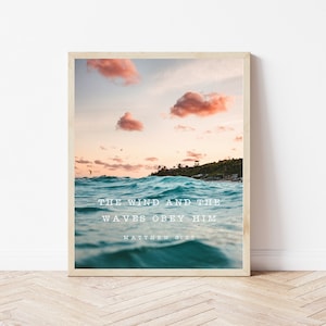 Può includere: Una stampa incorniciata con una citazione sul vento e le onde che obbediscono a Dio. L'immagine presenta un bellissimo tramonto sull'oceano con nuvole rosa nel cielo. La citazione dice "Il vento e le onde gli obbediscono. Matteo 8:27"