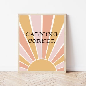 May include: A framed print with a yellow, pink, and orange sunburst design. The text "CALMING CORNER" is centered on the print.